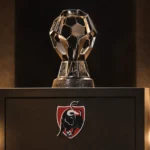 De Jupiler Pro League-trofee op een verlicht prijzenpodium.
