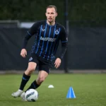 Gustaf Nilsson traint individueel op het oefenveld in zijn donker gestreepte tenue.
