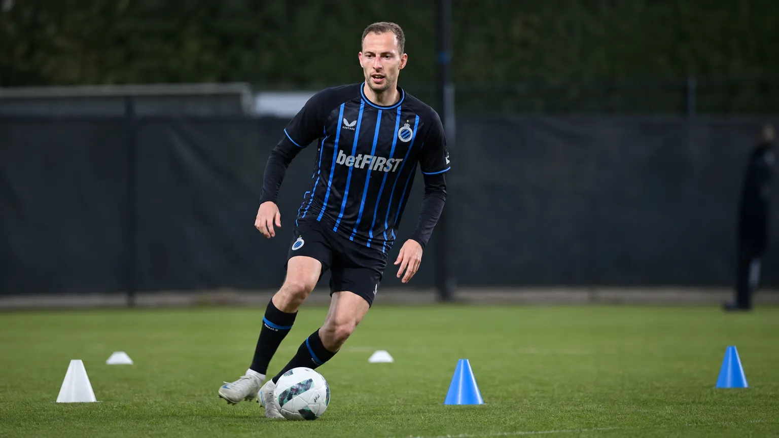 Gustaf Nilsson traint individueel op het oefenveld in zijn donker gestreepte tenue.