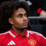 Joshua Zirkzee zit in een rood Manchester United-shirt op de invallersbank.