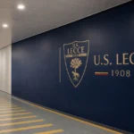 Een lege clubgang bij Lecce met subtiele clubbranding op de vaste wand.