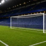 Het verlichte doelgebied van Chelsea in een leeg stadion na de wedstrijd.