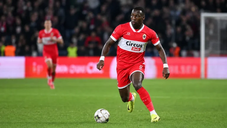 Marwan Al-Sahafi in een rood wedstrijdtenue tijdens een voetbalactie.