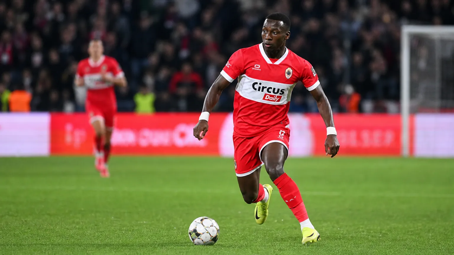 Marwan Al-Sahafi in een rood wedstrijdtenue tijdens een voetbalactie.