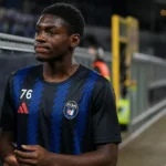 Jérémy Mbambi in zijn Pisa-tenue langs de rand van een stadionveld.