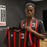 Aaron Kamardin poseert met een RWDM Brussels-shirt tijdens zijn officiële voorstelling.