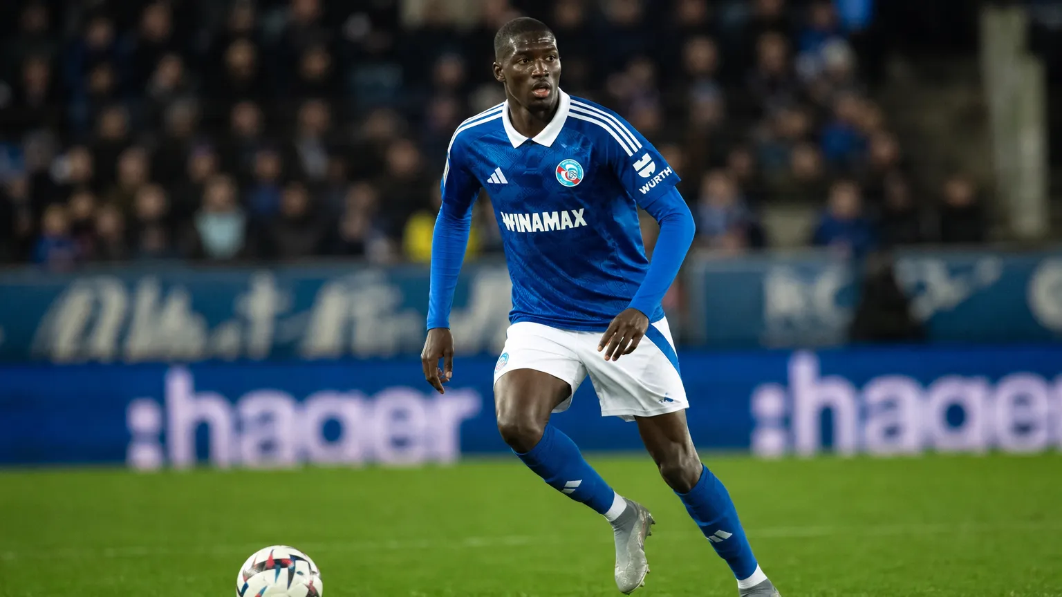 Pape Diong in een blauw tenue tijdens een voetbalwedstrijd.