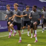 Een groep Anderlecht-spelers warmt op het veld op in het Lotto Park.
