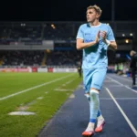 Max Dean van KAA Gent aan de zijlijn van een voetbalveld.