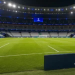 Een verlicht voetbalveld in een Champions League-stadion vlak voor de aftrap.