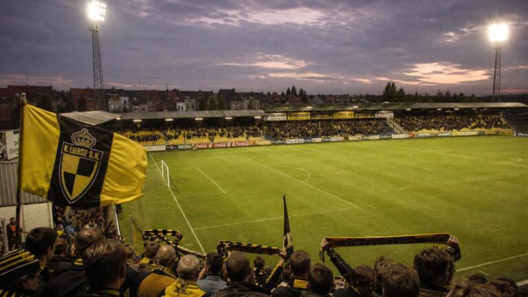 Het Herman Vanderpoortenstadion in Lier domineert de scène, met geel-zwarte tribunes en supporters van K. Lierse SK.