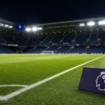 Verlicht Premier League-veld in een gevuld stadion met een discreet competitiesymbool langs de zijlijn