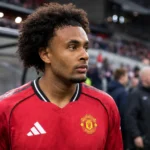 Joshua Zirkzee in het tenue van Manchester United langs de rand van het veld.