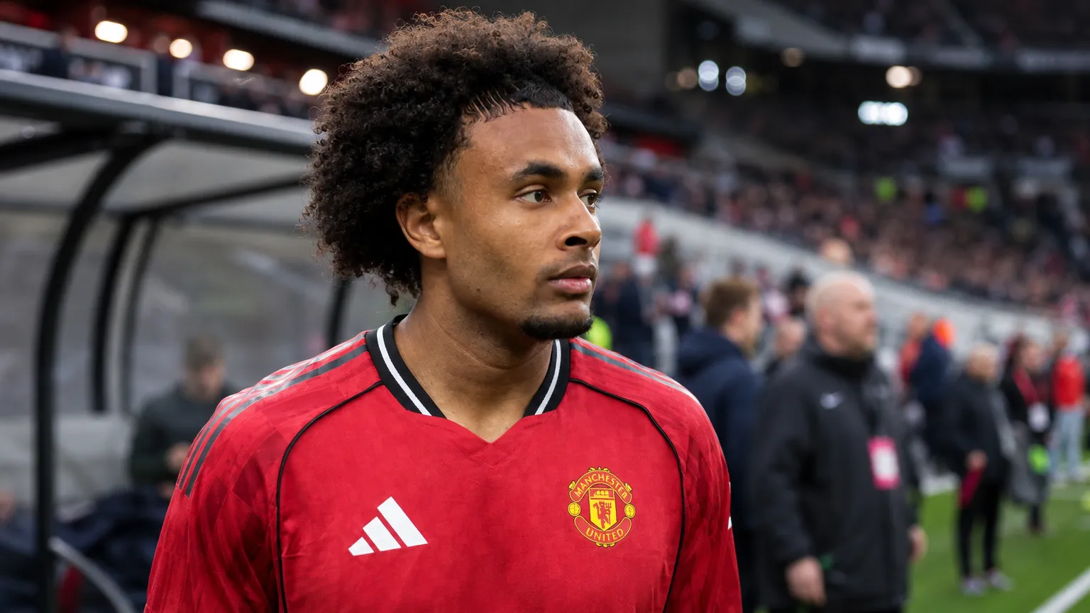 Joshua Zirkzee in het tenue van Manchester United langs de rand van het veld.