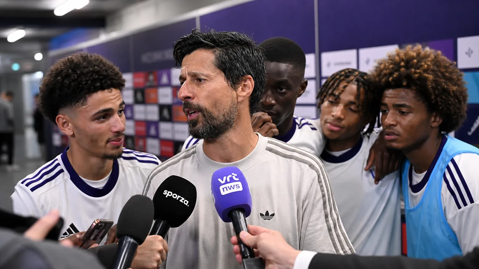 Vitor Bruno reageert in de mixed zone terwijl enkele spelers naast hem staan.