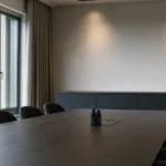 Een rustige vergaderruimte in een STVV-clubomgeving met een discreet clubanker aan de wand.