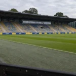 Lege zijlijn en tribunezone in het stadion van Union met een discrete clubvlag.