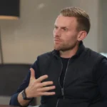 Edward Still tijdens een rustig voetbalinterview in een neutrale binnenruimte.