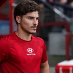 Julian Alvarez in zijn rode Atlético Madrid-kleding naast de dug-out.