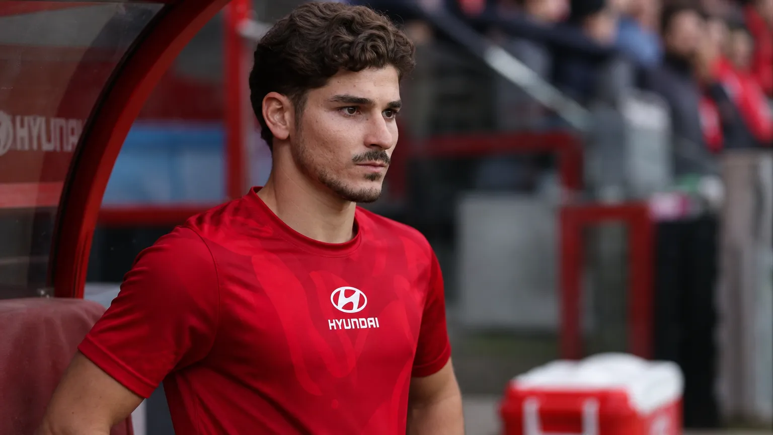 Julian Alvarez in zijn rode Atlético Madrid-kleding naast de dug-out.