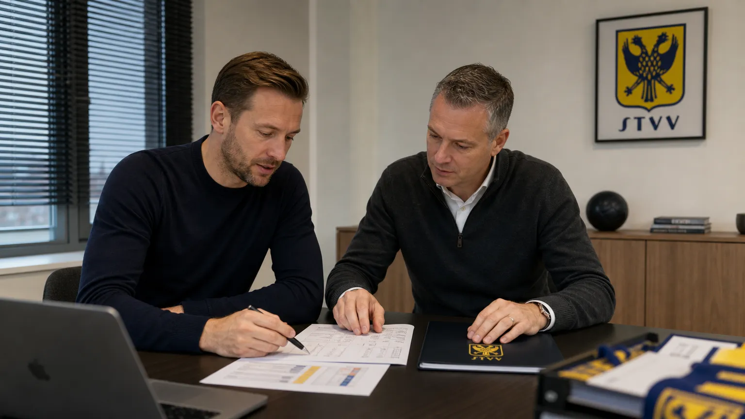 Twee medewerkers overleggen in een kantoorruimte van STVV.