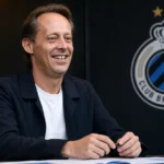 Een clubvertegenwoordiger van Club Brugge in een zakelijke voetbalomgeving.