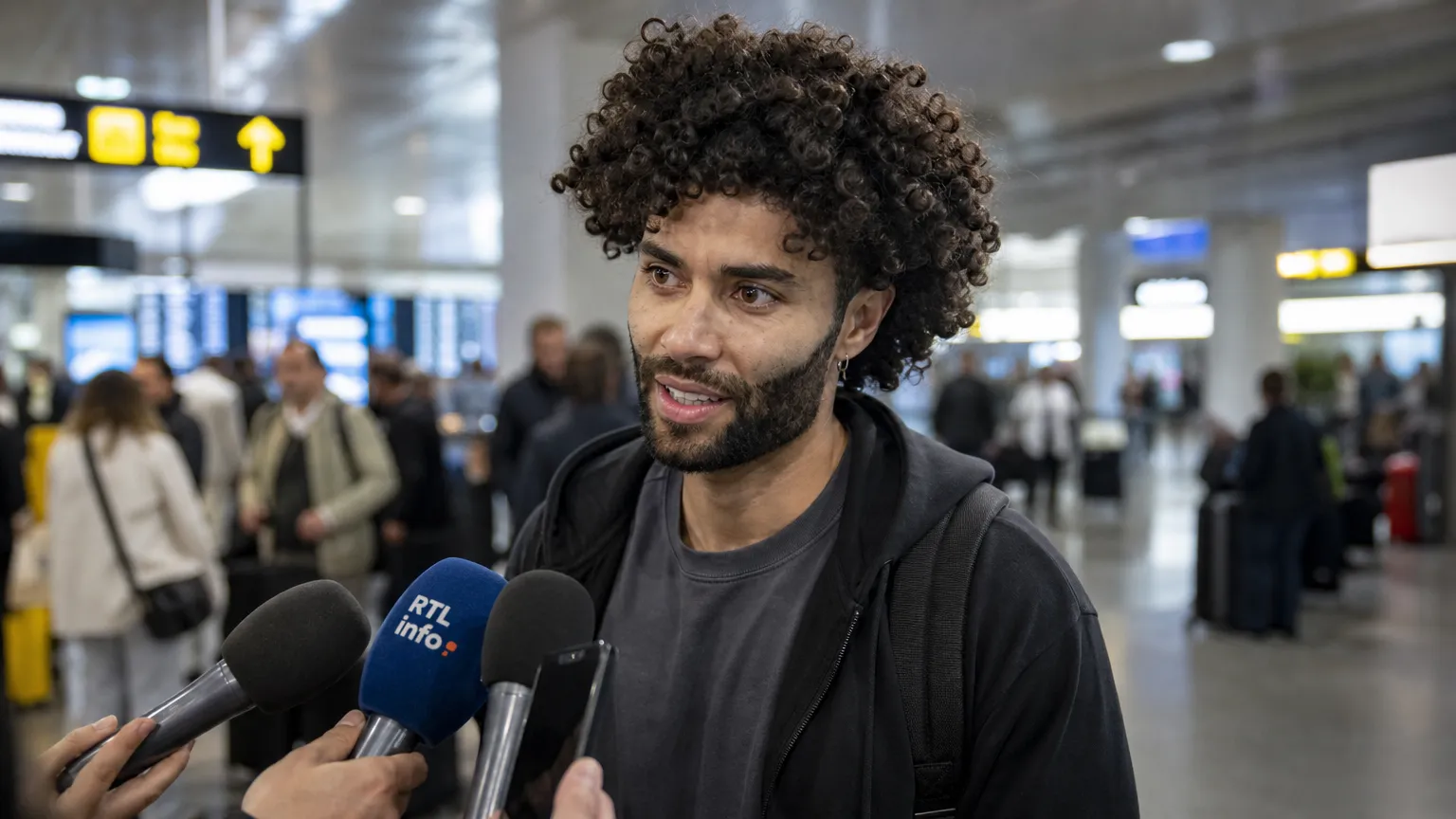 César Huerta spreekt journalisten toe in een luchthavenhal.