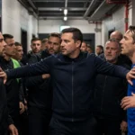 Voetballers en medewerkers worden na een wedstrijd uit elkaar gehouden in een stadiontunnel.