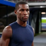 Nicolas Jackson in neutrale sportkleding in de spelerszone van een voetbalstadion.
