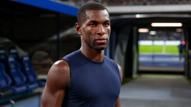 Nicolas Jackson in neutrale sportkleding in de spelerszone van een voetbalstadion.