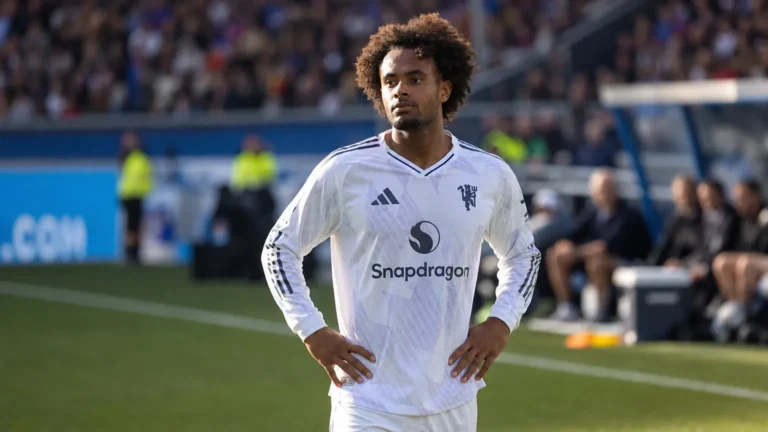 Joshua Zirkzee in een wit Manchester United-tenue langs de rand van het veld.
