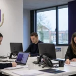 Communicatiemedewerkers in een kantoor van RSC Anderlecht tijdens een officiële clubaankondiging.