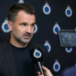 Ivan Leko spreekt voor een microfoon in een mixed zone met Club Brugge-branding op de achtergrond.