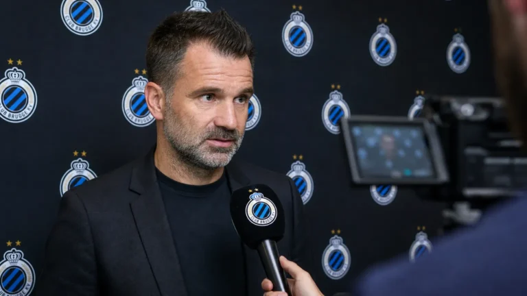 Ivan Leko spreekt voor een microfoon in een mixed zone met Club Brugge-branding op de achtergrond.