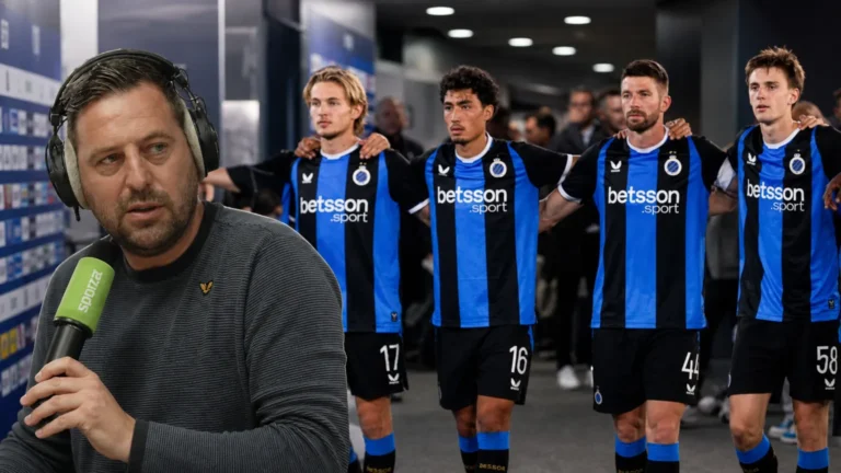 Frank Boeckx spreekt voor een microfoon met blauw-zwarte voetballers op de achtergrond.