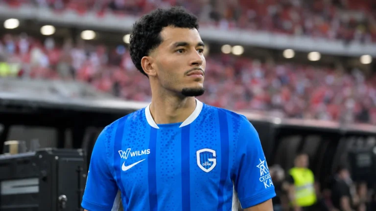 Zakaria El Ouahdi in het blauwe shirt van KRC Genk aan de zijlijn van een stadion.