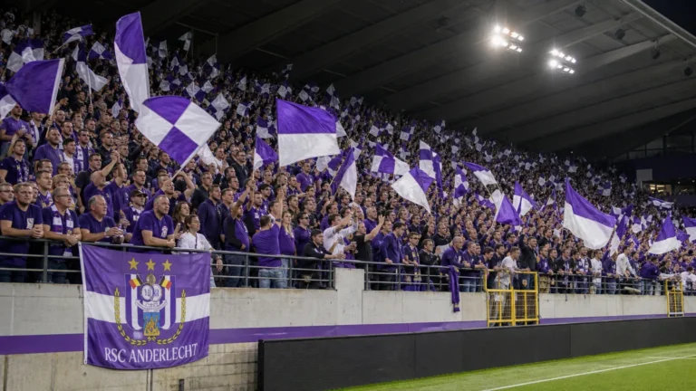 Supporters van RSC Anderlecht met paars-witte vlaggen op de tribune van het Lotto Park.