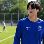 Atsuki Ito in blauwe KAA Gent-trainingskleding aan de rand van een trainingsveld.