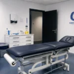Voorbereide medische testruimte met een discreet KAA Gent-wanddetail.