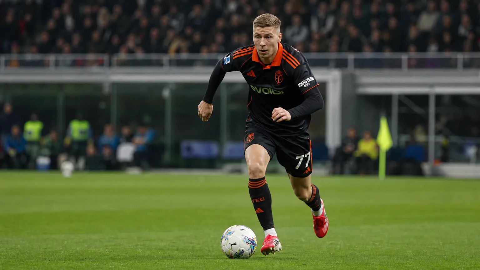 Ignace Van der Brempt in zwart-oranje tenue tijdens een voetbalactie met de bal.