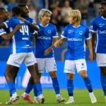 Spelers van KRC Genk vieren samen een doelpunt op het veld.