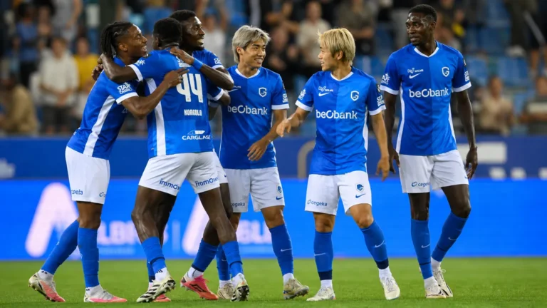 Spelers van KRC Genk vieren samen een doelpunt op het veld.
