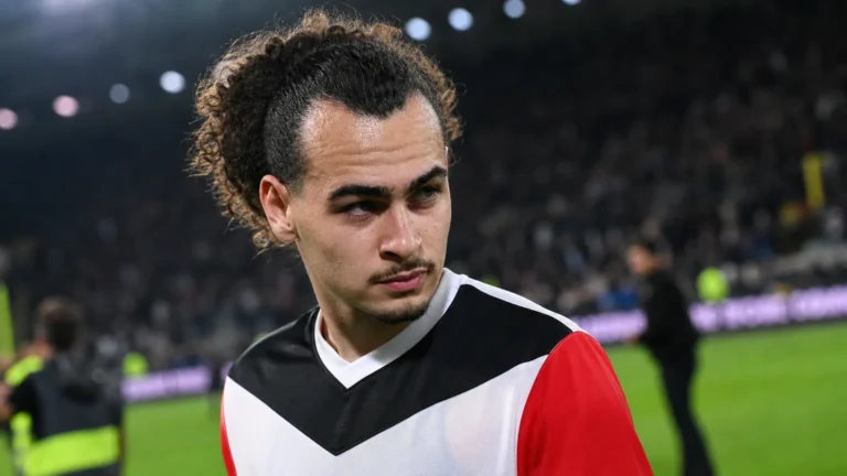 Arthur Theate in zijn voetbaltenue aan de rand van het veld.
