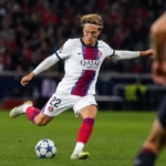 Mika Godts speelt de bal tijdens een wedstrijdmoment voor PSG.