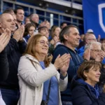 Supporters van KRC Genk applaudisseren in de tribunes na een wedstrijd.