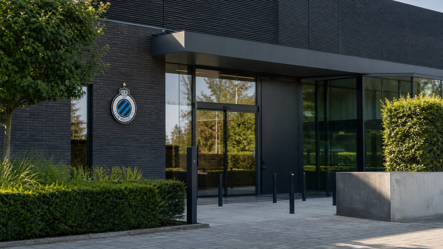 Ingang van het clubgebouw van Club Brugge met een discreet clubembleem aan de gevel.