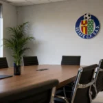 Rustige ontvangstzone van een clubkantoor in Getafe met een discreet wandembleem.