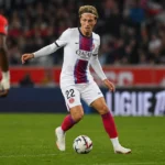 Mika Godts in een wit PSG-tenue tijdens een wedstrijdactie met de bal.