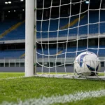 Een wedstrijdbal ligt na een doelpunt in het net van een voetbaldoel.
