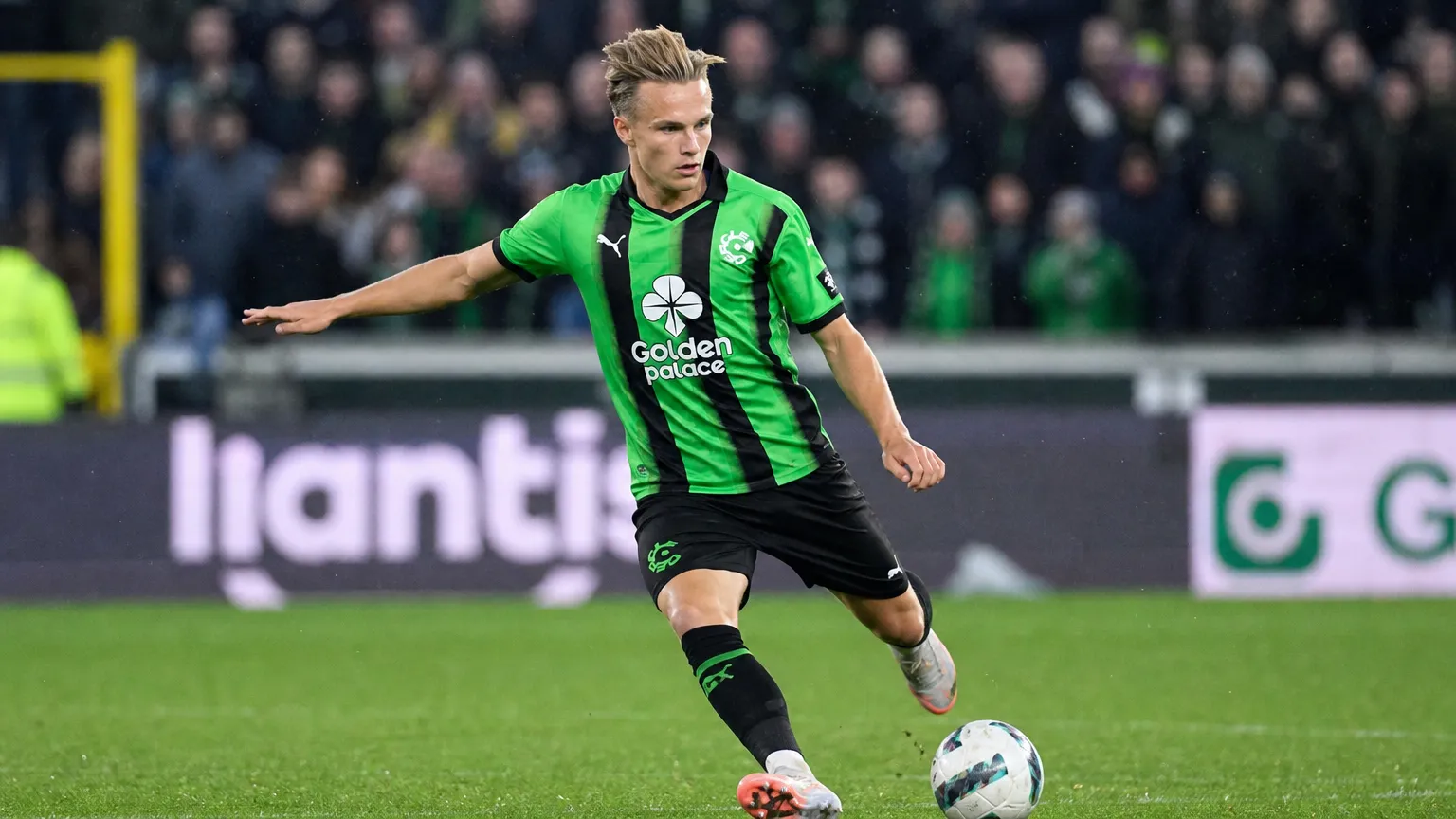 Christiaan Ravych in groen-zwart tenue tijdens een verdedigende actie op het veld.